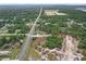 This aerial shot captures the home's position within a serene neighborhood surrounded by lush greenery and open fields at 11042 Heth Ct, Weeki Wachee, FL 34613