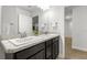 Well-lit bathroom includes double sinks with granite countertops, dark cabinets, and tile floors at 11042 Heth Ct, Weeki Wachee, FL 34613