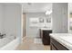 Bright bathroom featuring a soaking tub, glass shower, dark cabinets, and double sinks at 11042 Heth Ct, Weeki Wachee, FL 34613