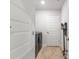 Well-lit laundry room with modern washer/dryer, sleek floors, and convenient storage at 11042 Heth Ct, Weeki Wachee, FL 34613