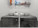 Modern laundry room equipped with front load washer and dryer and storage shelves at 11042 Heth Ct, Weeki Wachee, FL 34613
