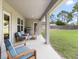 Covered patio with outdoor furniture and grill overlooks the lush green backyard at 11042 Heth Ct, Weeki Wachee, FL 34613