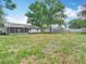 Large fenced backyard with ample green space and mature trees and sun room at 11340 Corinthian St, Spring Hill, FL 34609