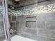 Beautiful bathroom shower area with gray tile, built-in niche, and chrome fixtures at 11340 Corinthian St, Spring Hill, FL 34609
