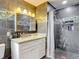 Stylish bathroom with gray tile, granite countertop vanity, and shower with built-in niche at 11340 Corinthian St, Spring Hill, FL 34609