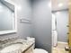 This bathroom features gray walls, white fixtures, and granite countertops at 11340 Corinthian St, Spring Hill, FL 34609