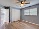 This bedroom features laminate flooring, a ceiling fan, a window with blinds, and a closet with bi-fold doors at 11340 Corinthian St, Spring Hill, FL 34609