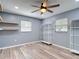 Bedroom with wood-look flooring, ceiling fan, shelving, and natural light from two windows at 11340 Corinthian St, Spring Hill, FL 34609