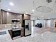 Open-concept kitchen features stainless steel appliances, granite countertops, and a view of the living area at 11340 Corinthian St, Spring Hill, FL 34609