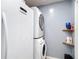 This laundry room features a stacked washer and dryer and wooden shelving at 11340 Corinthian St, Spring Hill, FL 34609