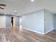 Spacious living room with wood-look floors and access to a bathroom at 11340 Corinthian St, Spring Hill, FL 34609