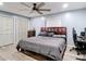 Bedroom featuring a ceiling fan, window, and closet space with a gray bed and decor, ensuring comfort and style at 11340 Corinthian St, Spring Hill, FL 34609