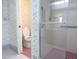 Bathroom featuring floral wallpaper, toilet, and glass-enclosed shower with grab bars for accessibility at 11364 Orangewood Ct, Spring Hill, FL 34609