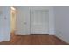 A bedroom with a closet and hardwood floors, with an open door to the bathroom at 11364 Orangewood Ct, Spring Hill, FL 34609