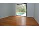 A bright bedroom with hardwood floors and sliding glass doors leading to the pool at 11364 Orangewood Ct, Spring Hill, FL 34609