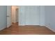 A bedroom with a closet and hardwood floors, with an open door leading to another room at 11364 Orangewood Ct, Spring Hill, FL 34609