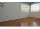 A bright bedroom features hardwood floors, white walls, and windows with sheer curtains at 11364 Orangewood Ct, Spring Hill, FL 34609