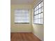 Bright bedroom with hardwood floors, yellow walls and multiple windows with horizontal blinds at 11364 Orangewood Ct, Spring Hill, FL 34609