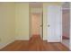 Bright bedroom with hardwood floors, yellow walls and an open doorway leading to another room at 11364 Orangewood Ct, Spring Hill, FL 34609
