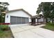 Charming single-story home with white exterior and a two-car garage and driveway at 11364 Orangewood Ct, Spring Hill, FL 34609