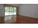 Bright living room featuring wood floors and sliding door access to the screened-in patio and pool at 11364 Orangewood Ct, Spring Hill, FL 34609