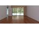 Bright living room featuring wood floors and sliding door access to the screened-in patio and pool at 11364 Orangewood Ct, Spring Hill, FL 34609