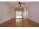 Bright living room with hardwood floors, ceiling fan, and sliding doors that lead to the backyard at 11364 Orangewood Ct, Spring Hill, FL 34609
