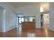 Open living space with wood floors and a view into the kitchen area at 11364 Orangewood Ct, Spring Hill, FL 34609