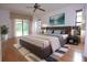 Main bedroom with wood floors, a large bed, and sliding door access to the patio at 11364 Orangewood Ct, Spring Hill, FL 34609