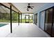 Spacious screened-in patio featuring a ceiling fan and access to the backyard pool at 11364 Orangewood Ct, Spring Hill, FL 34609