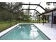 A screened-in pool surrounded by trees and a white deck with a full view of backyard at 11364 Orangewood Ct, Spring Hill, FL 34609
