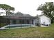 Enclosed in a screen cage, a simple rectangular pool sits in the backyard at 11364 Orangewood Ct, Spring Hill, FL 34609