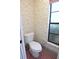 Half bathroom featuring floral wallpaper, tile flooring, window, and a standard toilet at 11364 Orangewood Ct, Spring Hill, FL 34609