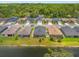 Aerial view of homes backing onto a pond, showcasing screened patios, and surrounding green space at 11579 Weaver Hollow Rd, New Port Richey, FL 34654