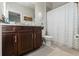 Bathroom featuring a single vanity with granite countertop, a toilet, and a shower with a curtain at 11579 Weaver Hollow Rd, New Port Richey, FL 34654