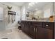 The bathroom offers double sinks, dark wood cabinets, granite counters, and a stylish walk-in shower at 11579 Weaver Hollow Rd, New Port Richey, FL 34654