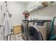 Well-equipped laundry room with modern washer and dryer, convenient shelving, and stylish wood-look tile flooring at 11579 Weaver Hollow Rd, New Port Richey, FL 34654