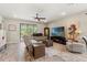Bright living room with tile flooring, a ceiling fan, comfortable seating, and sliding glass doors to the lanai at 11579 Weaver Hollow Rd, New Port Richey, FL 34654