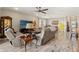Open-concept living area with tile floors, comfortable seating, a ceiling fan, and views into the dining area at 11579 Weaver Hollow Rd, New Port Richey, FL 34654