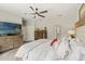 Bright main bedroom boasts a ceiling fan, dresser with a TV and an ensuite bathroom at 11579 Weaver Hollow Rd, New Port Richey, FL 34654