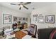 Spacious home office featuring a ceiling fan, wood-look floors, and various framed photos and decor at 11579 Weaver Hollow Rd, New Port Richey, FL 34654
