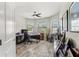 Home office with wood-look floors, large windows, ceiling fan, and views of the outside at 11579 Weaver Hollow Rd, New Port Richey, FL 34654