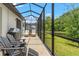 Spacious screened patio with lounge chairs, a grill, and scenic views of the serene lake at 11579 Weaver Hollow Rd, New Port Richey, FL 34654