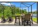 Enjoy beautiful lake views from this screened patio with a table set and lounge seating at 11579 Weaver Hollow Rd, New Port Richey, FL 34654