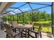 Relax in this screened patio featuring a table and chairs overlooking a beautiful lake at 11579 Weaver Hollow Rd, New Port Richey, FL 34654