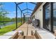 Large screened-in patio with a lake view and patio furniture, perfect for relaxing outdoors at 11579 Weaver Hollow Rd, New Port Richey, FL 34654