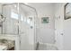 Bright bathroom featuring a glass-enclosed shower with white tile and a neutral vanity top at 11637 Spindrift Loop, Hudson, FL 34667