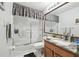 Bathroom vanity with a large mirror and a shower with a sliding glass door at 11637 Spindrift Loop, Hudson, FL 34667