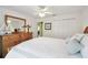 Bright bedroom with white bedding, wood dresser and mirror, plus a ceiling fan at 11637 Spindrift Loop, Hudson, FL 34667