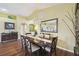 Elegant dining area with a large mirror, stylish lighting fixture, and hardwood floors at 11637 Spindrift Loop, Hudson, FL 34667